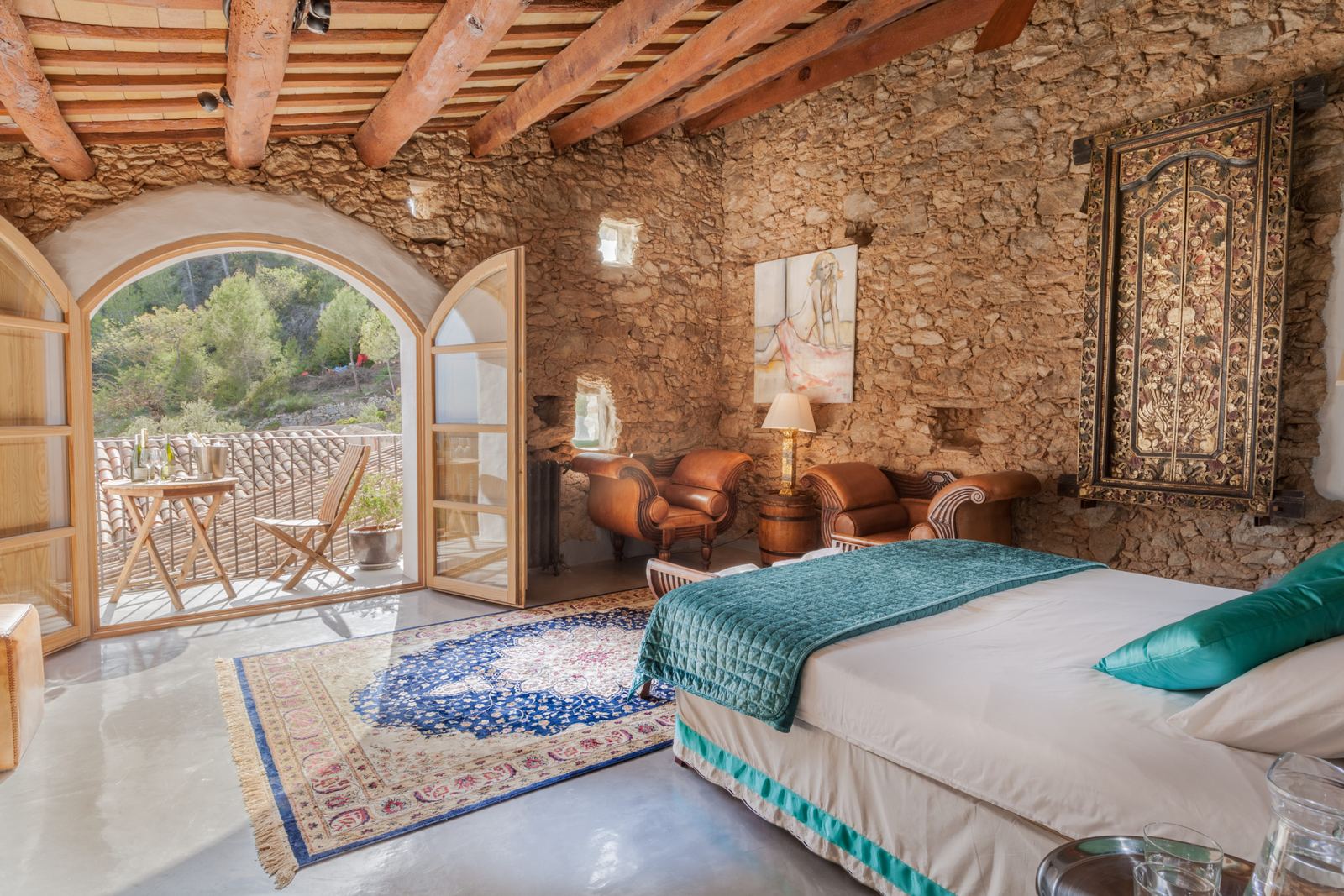 Bedroom with timber beams opening onto a terrace