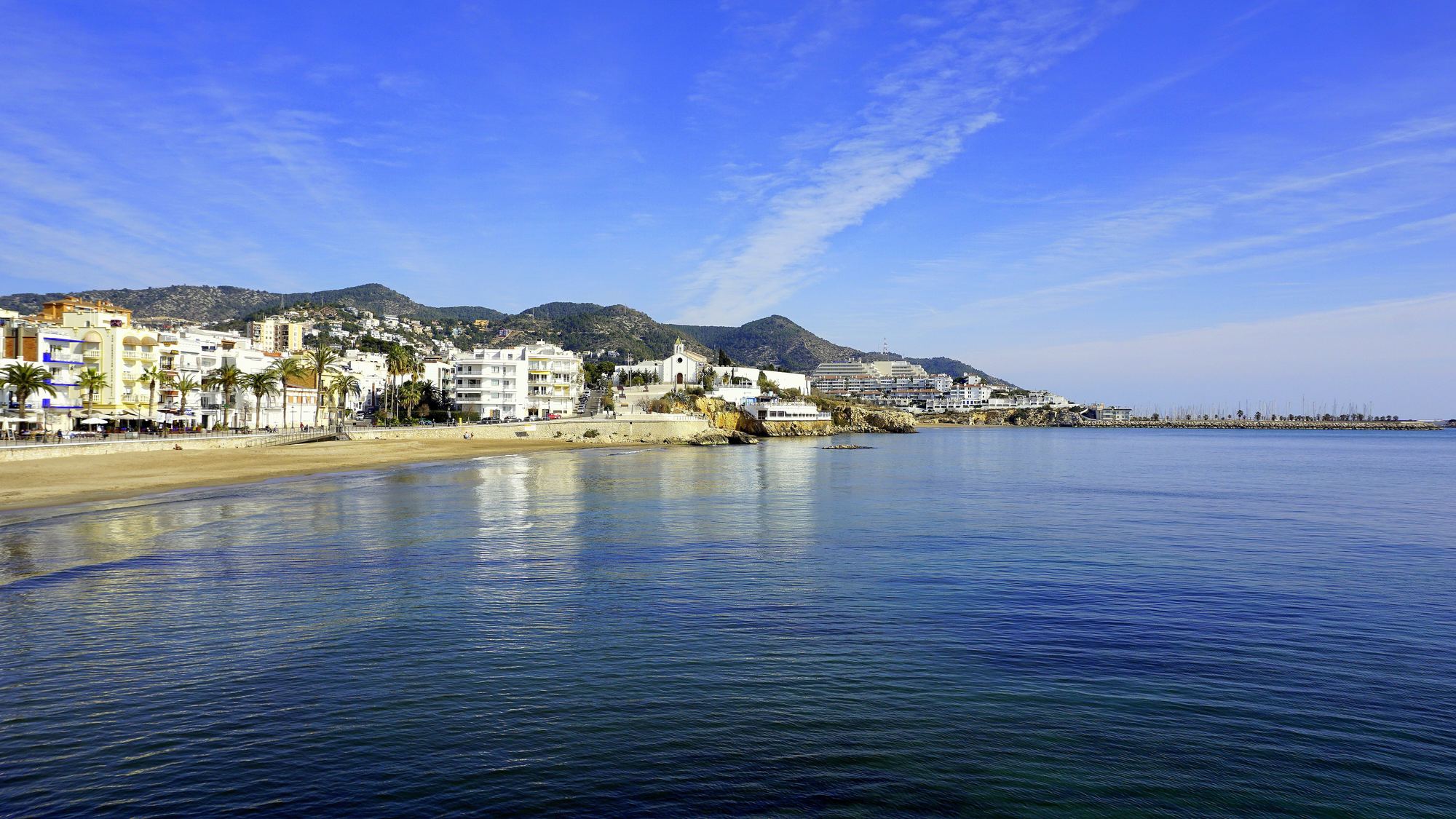 Bahía de Sitges con el paseo marítimo y las montañas del Garraf