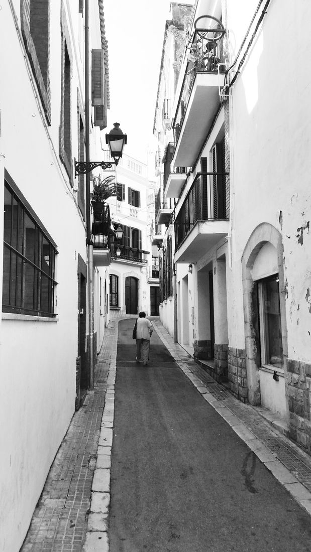 Calle estrecha del casco antiguo de Sitges en blanco y negro